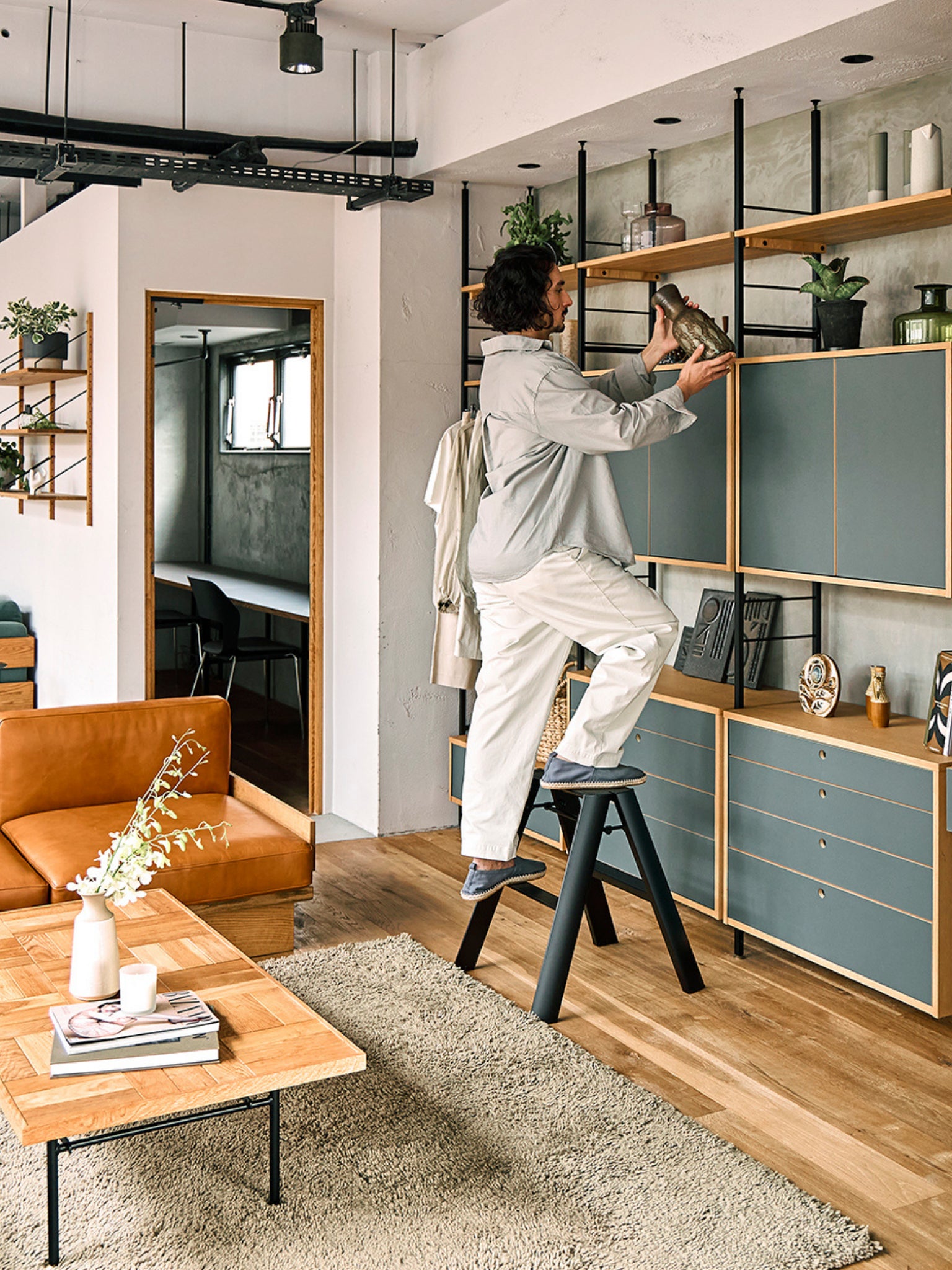 zwarte design ladder als hulp bij een wandkast