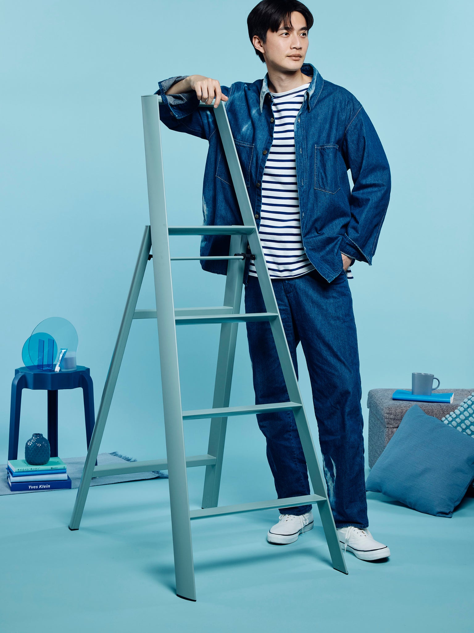man naast 4 step ladder dusty mint in een blauw getinte kamer